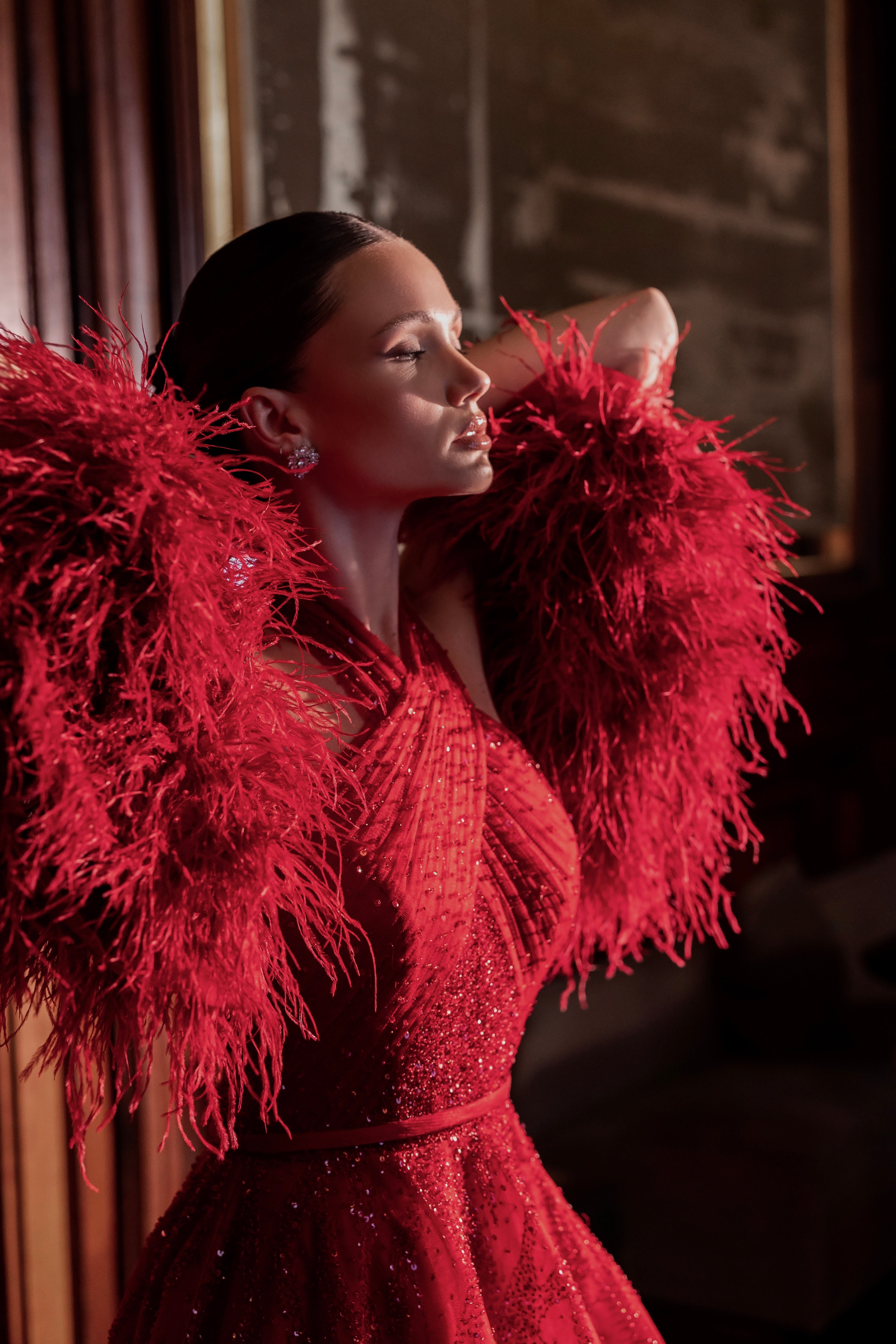 Red embroidered dress decorated with feathers and crystals