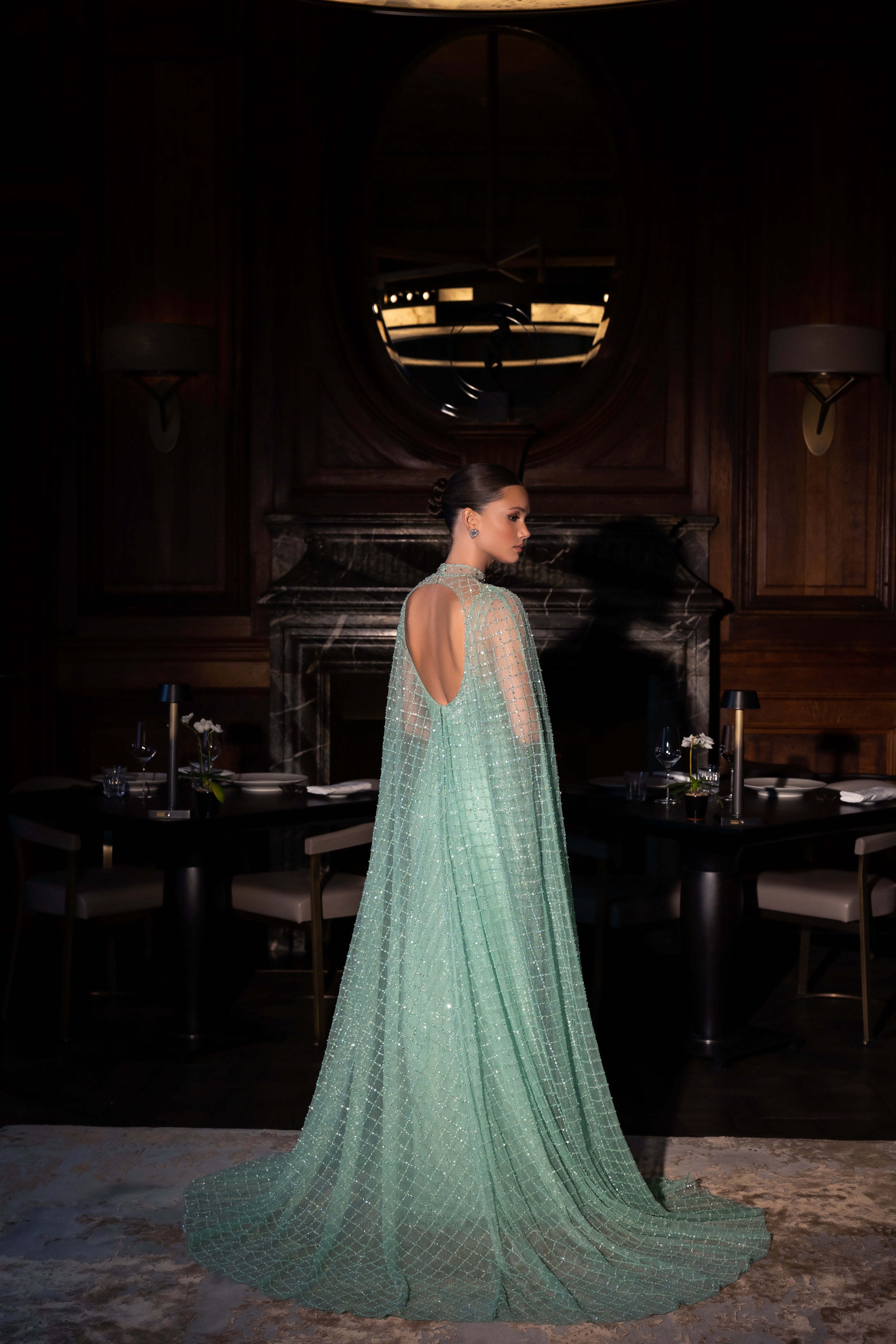 Long evening dress with an open back in green, decorated with stones, sequins and beads